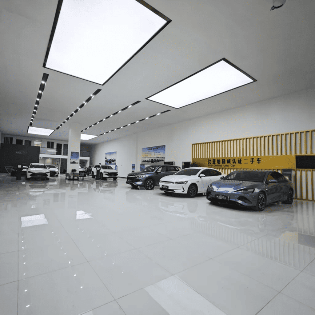 Modern showroom at YT Automobile Export displaying certified used EVs and gasoline cars for sale.